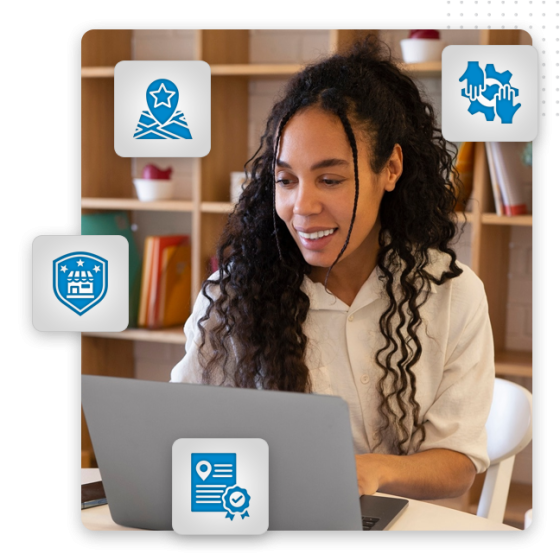 A person with long curly hair smiles while using a laptop at a desk, exploring Google My Business optimization. Four blue icons—a map pin, handshake, badge, and achievement—are overlaid, with bookshelves in the background.